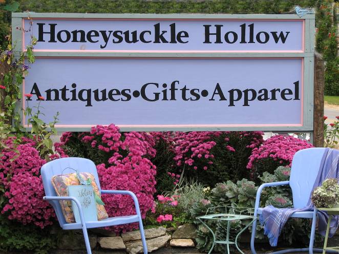 Sign and floral garden in front of store: Honeysuckle Hollow, Antiques, Gifts, Apparel